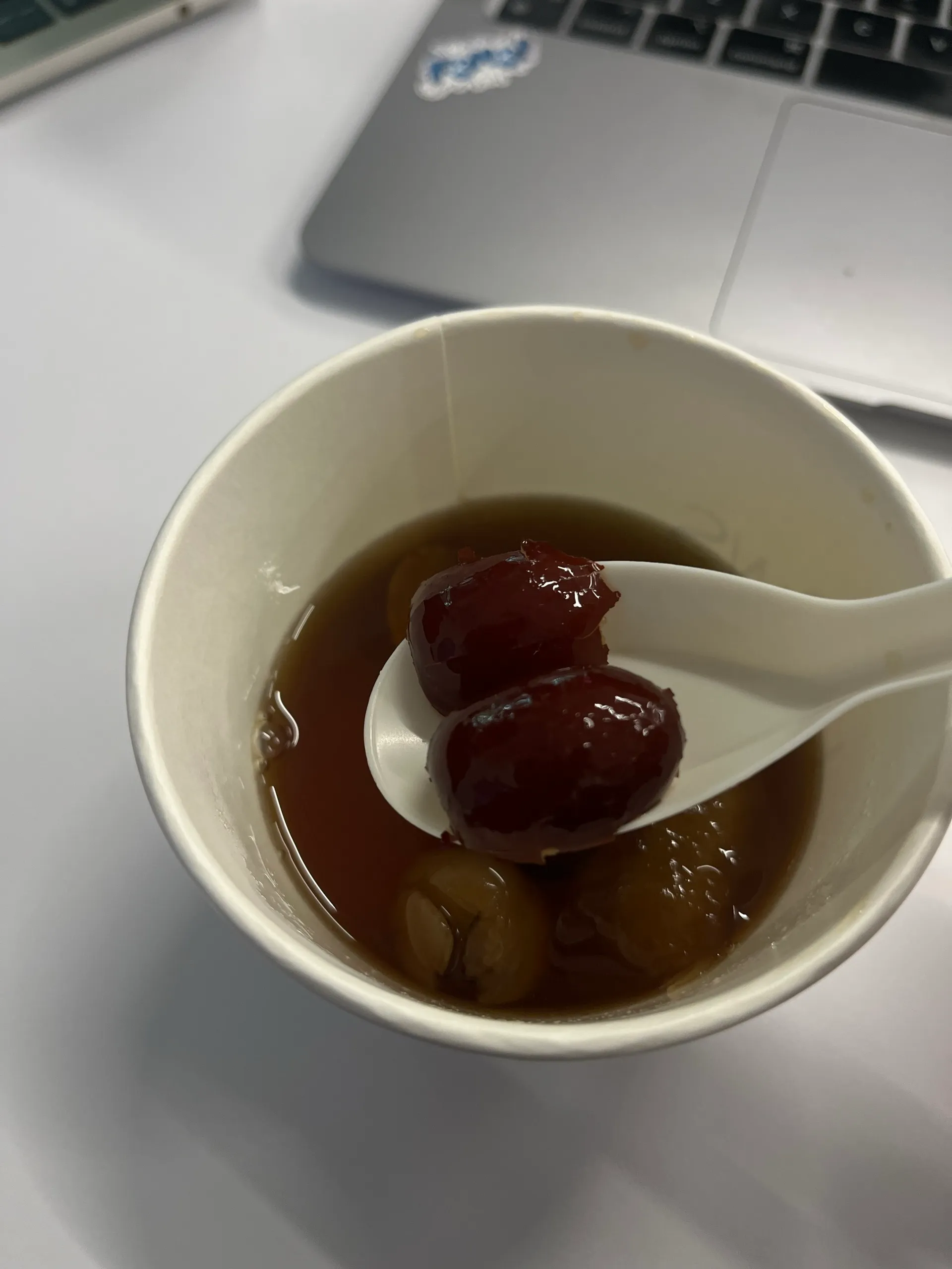A cup of warm dessert next to the laptop, keeping the afternoon alive