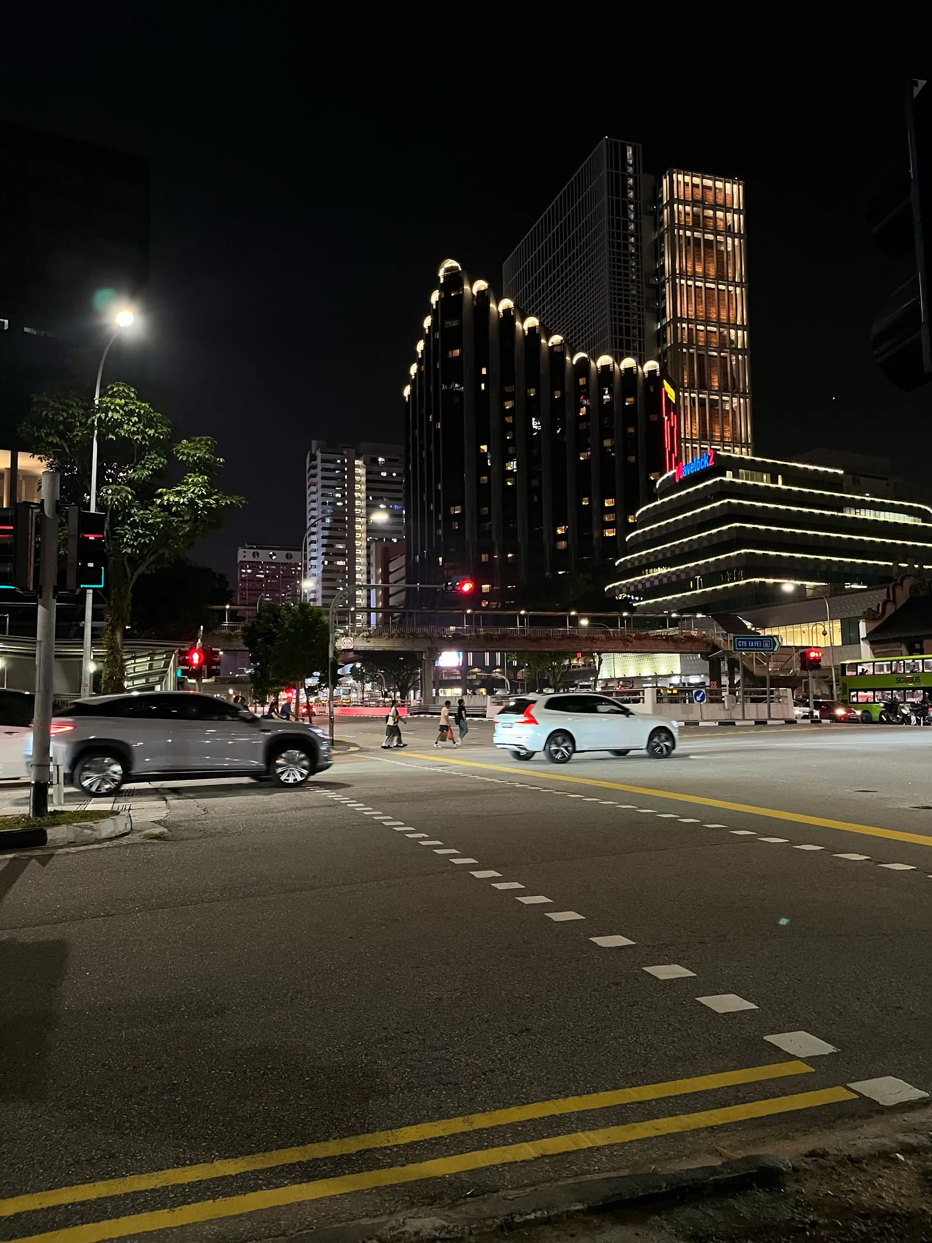 Singapore at night on the walk back, lit buildings over an empty crossing